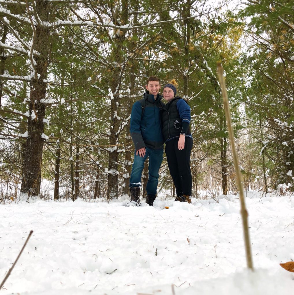 Hannah and Dylan with snowshoes in woods