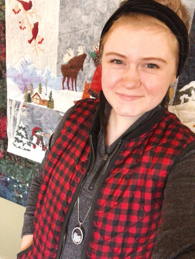 Hannah wearing Snowshoe locket with red vest